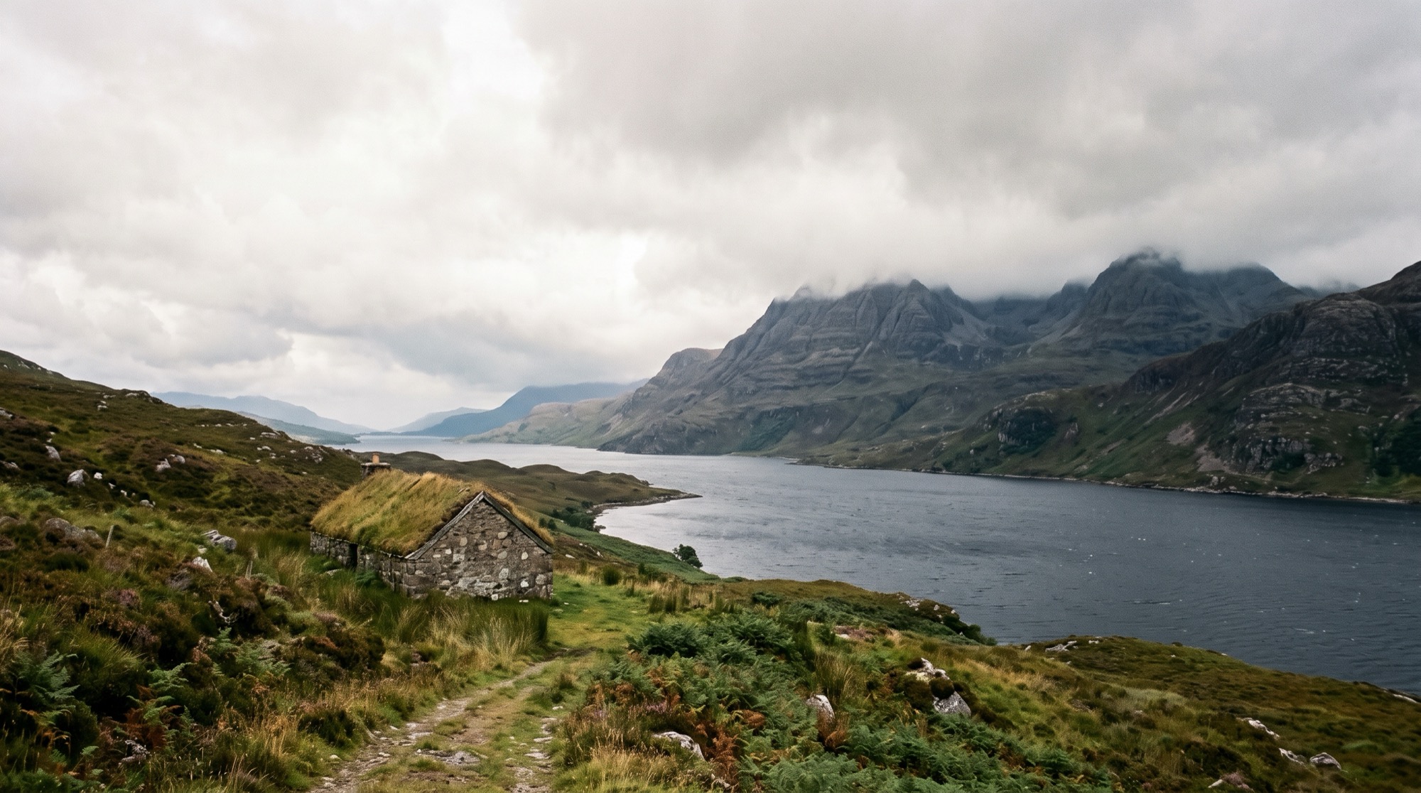 The remote north-west coast of Scotland, a turf-roofed croft above a sea loch